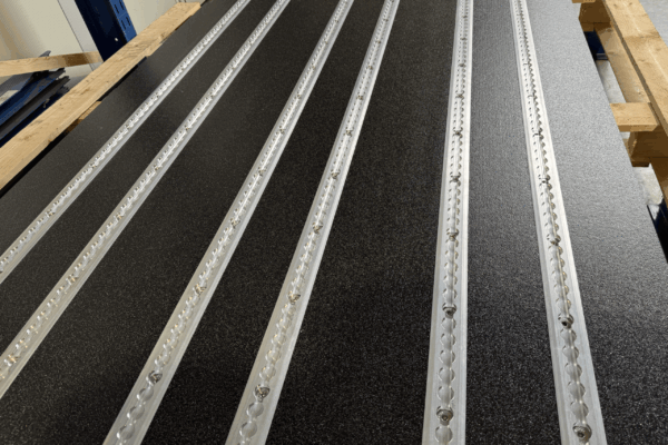 Smartfloor Design Black Storm. Black floor with a rough surface and silver Smartfloor rails.