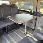 Camping table for an airline rail in the interior